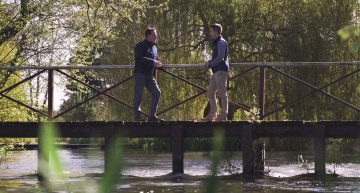 Thomas Niven and Nick Sandall on a bridge over a river having a conversation