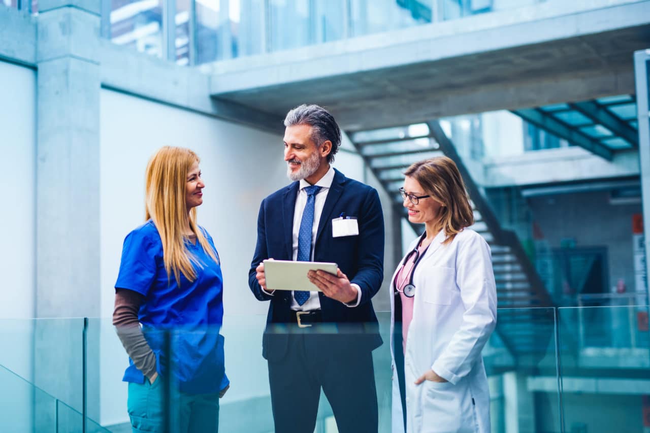 Pharma people talking an smiling and holdning an ipad