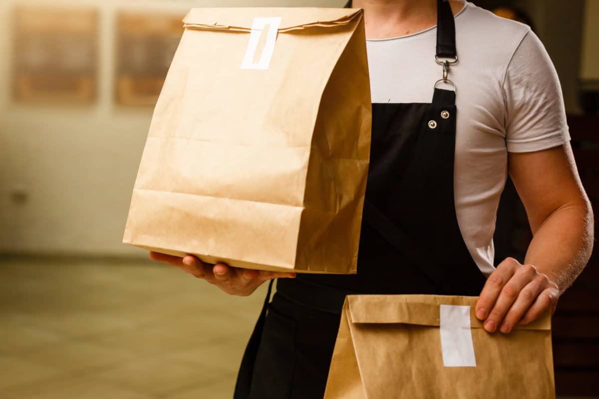 Chef holding bags of takeaway food