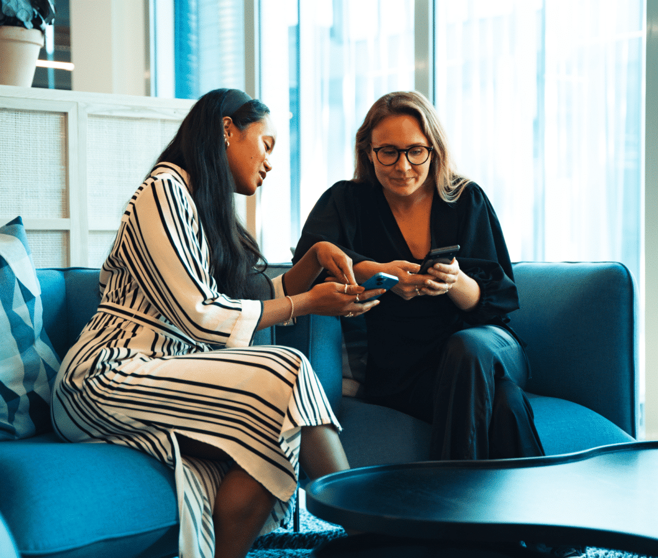 two woman playing leadership training on their phones